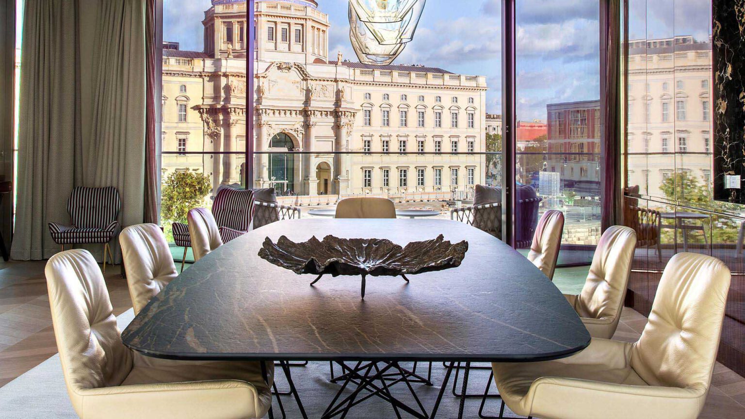 Dining area at Nº3 Schinkelplatz in Berlin-Mitte with large designer table and view of the palace