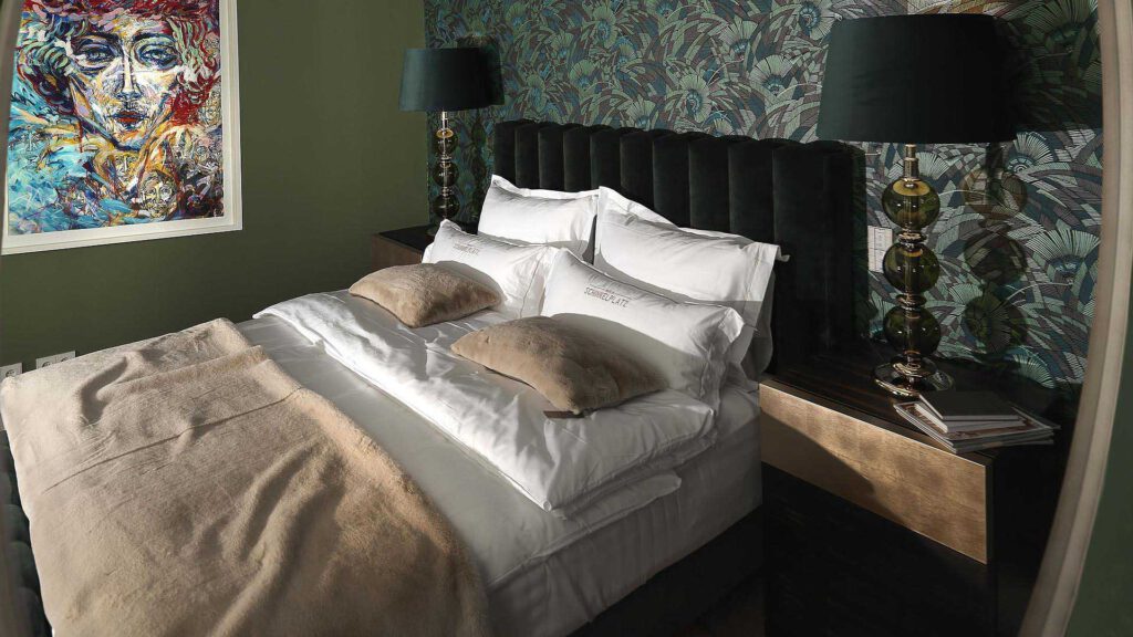 Bedroom at Nº3 Schinkelplatz in Berlin-Mitte with upholstered bed, artwork and textured wall design