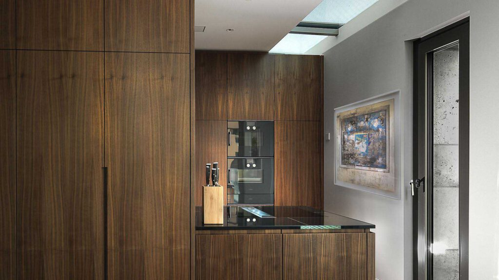 Kitchen at Nº3 Schinkelplatz in Berlin-Mitte with wooden fronts, integrated hob and skylight