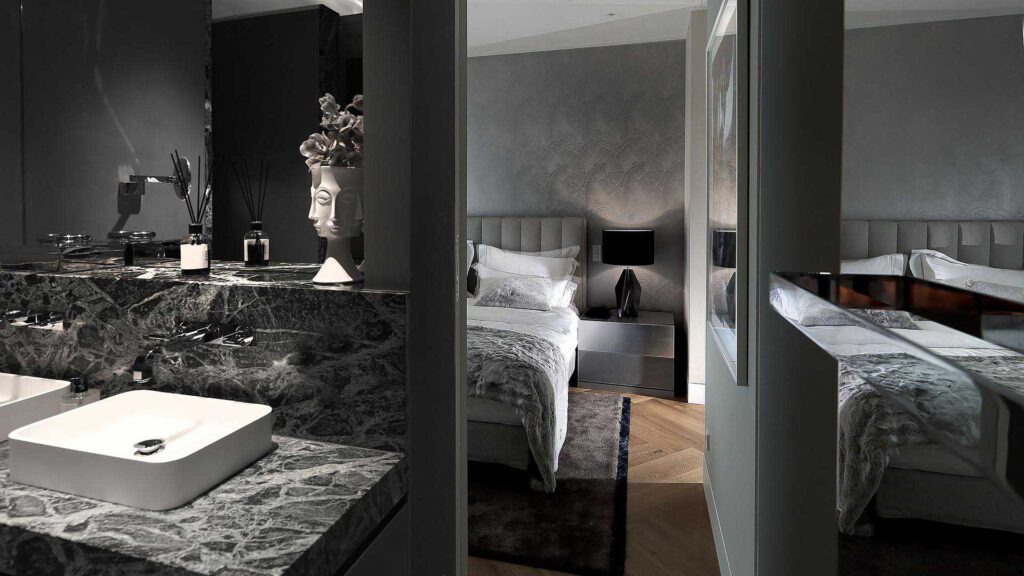 Bathroom and bedroom in Nº3 Schinkelplatz in Berlin-Mitte with natural stone, double washbasin and view into the sleeping area