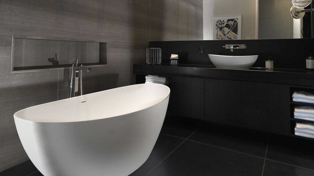 Bathroom at Nº3 Schinkelplatz in Berlin-Mitte with free-standing bathtub and dark stone look