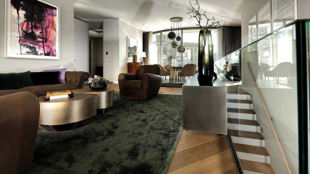 Open-plan living area in Nº3 Schinkelplatz in Berlin-Mitte with staircase, designer furniture and spacious room concept